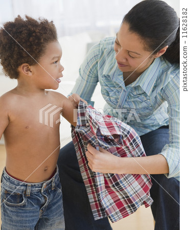Mixed race mother helping son to dress Mixed race mother helping son to dress 11628182