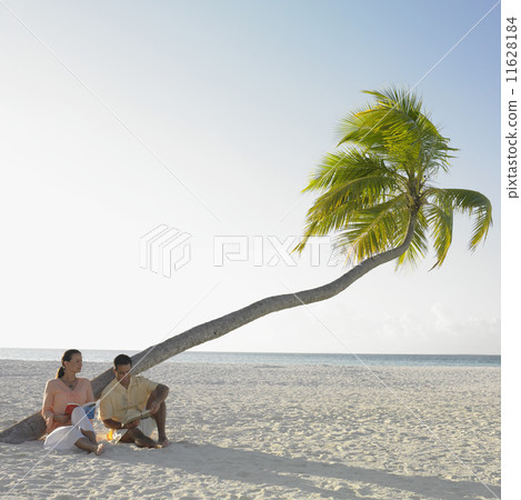 Couple reading at the beach Couple reading at the beach 11628184