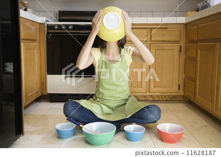 Asian woman with mixing bowls on floor 11628187