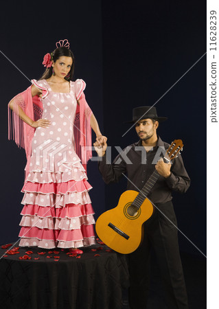 Hispanic female flamenco dancer holding hands with guitar player 11628239