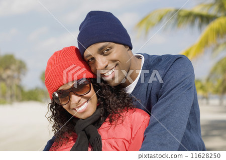 Multi-ethnic couple hugging 11628250