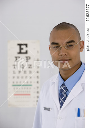 Male doctor in front of eye chart Male doctor in front of eye chart 11628277