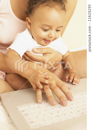 Mother and baby using laptop together Mother and baby using laptop together 11628295