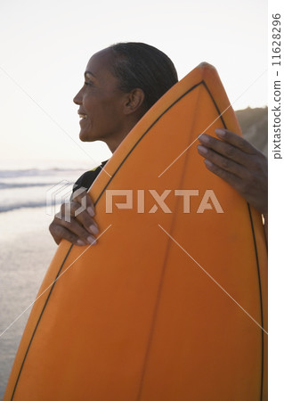 Mixed Race woman holding surfboard Mixed Race woman holding surfboard 11628296