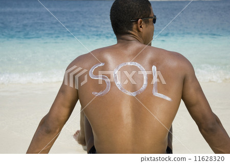 Hispanic man sitting on beach 11628320