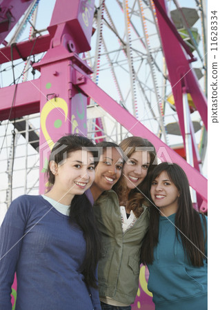 Multi-ethnic girls in front of Ferris wheel 11628334