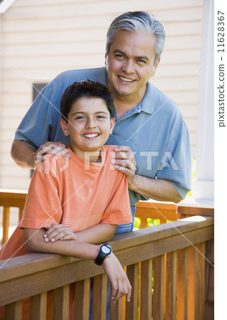 Hispanic father and son smiling on porch Hispanic father and son smiling on porch 11628367