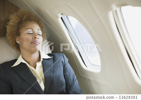 African American businesswoman sleeping on airplane 11628381