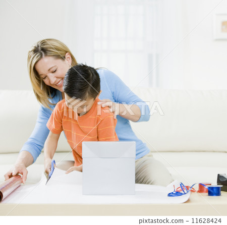 Mother and son wrapping gift 11628424