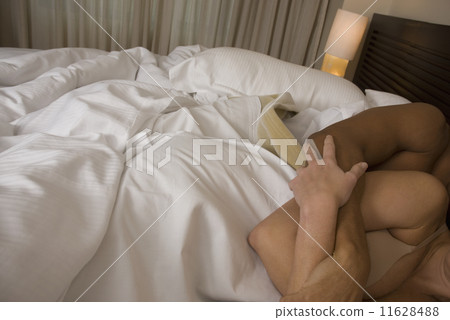 Hispanic couple hugging in bed 11628488