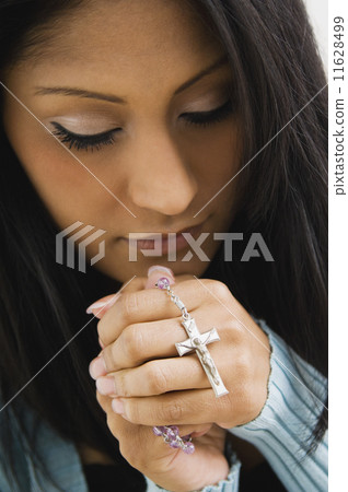 Hispanic woman holding rosary beads 11628499
