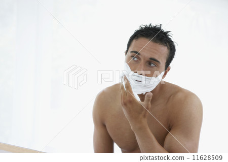 Man with bare chest applying shaving cream to face Man with bare chest applying shaving cream to face 11628509