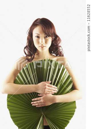Asian woman covered by large leaf Asian woman covered by large leaf 11628552