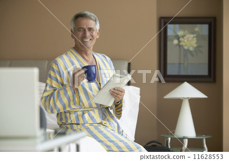 Hispanic man holding coffee and newspaper Hispanic man holding coffee and newspaper 11628553