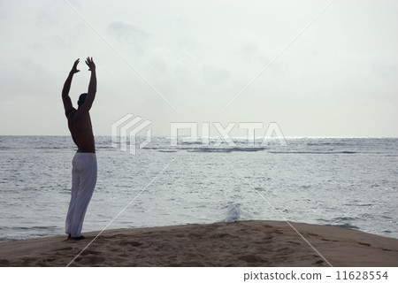 Hispanic man practicing yoga at beach Hispanic man practicing yoga at beach 11628554