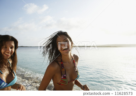 South American women running at beach South American women running at beach 11628573