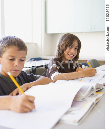 Two boys working at desk in classroom 11628616