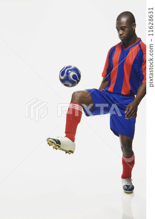 African American male soccer player kicking ball African American male soccer player kicking ball 11628631