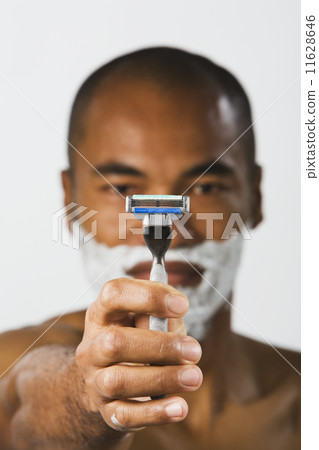 Asian man holding up razor Asian man holding up razor 11628646