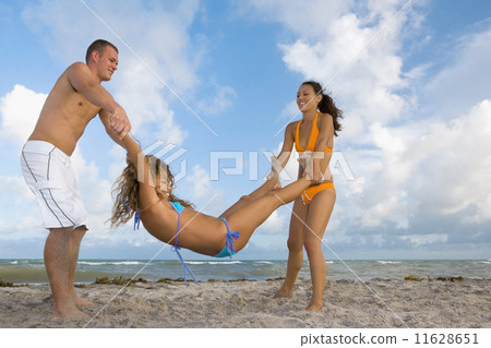 Multi-ethnic friends playing at beach 11628651