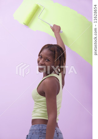 African American woman painting with roller African American woman painting with roller 11628654