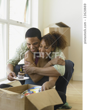 Young man giving his girlfriend a birthday cupcake 11628669