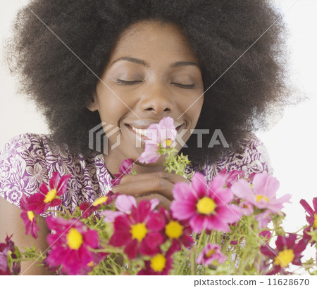 Close up of African woman smelling flowers Close up of African woman smelling flowers 11628670