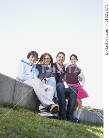 Multi-ethnic family sitting outdoors Multi-ethnic family sitting outdoors 11628673