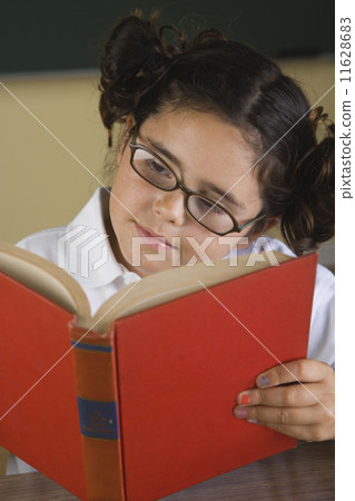 Hispanic girl wearing eye glasses and reading book 11628683