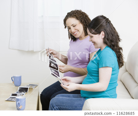 Multi-ethnic pregnant women looking at ultrasounds 11628685