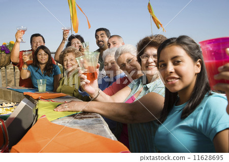 Large Hispanic family toasting at party outdoors 11628695