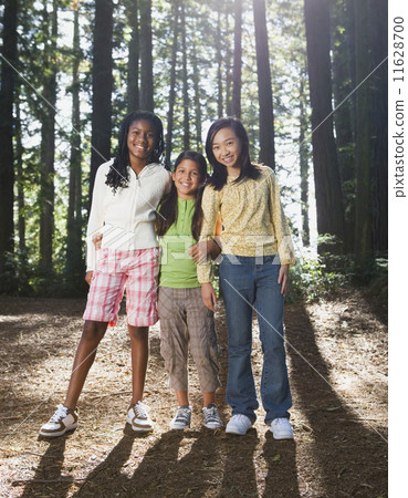 Multi-ethnic girls standing in woods Multi-ethnic girls standing in woods 11628700