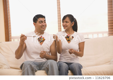 Hispanic couple eating fruit salad Hispanic couple eating fruit salad 11628706