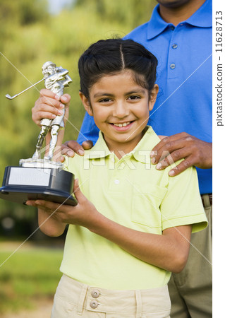 Hispanic girl holding golf trophy 11628713