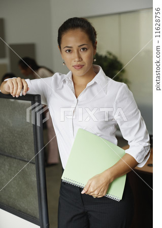 Asian businesswoman leaning on cubicle wall Asian businesswoman leaning on cubicle wall 11628756