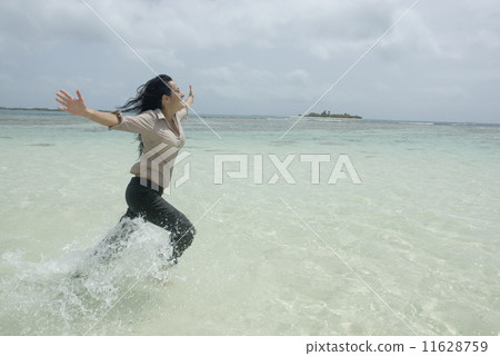 Hispanic businesswoman running in water 11628759