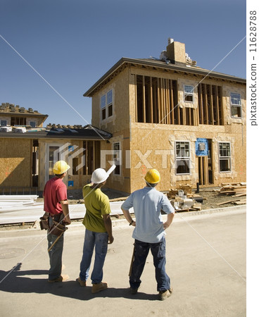 Male construction workers looking at construction site Male construction workers looking at construction site 11628788