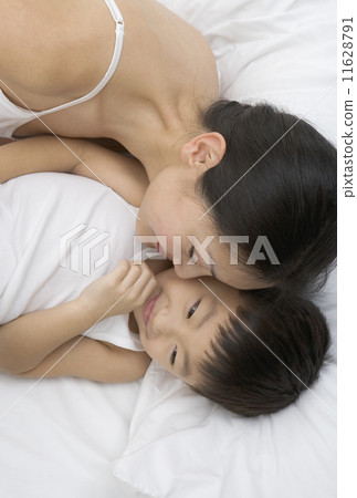 High angle view of mother laying in bed with son High angle view of mother laying in bed with son 11628791