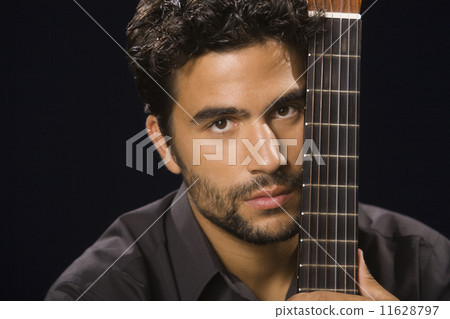 Hispanic man holding acoustic guitar 11628797