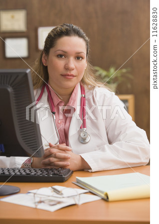Hispanic female doctor at desk Hispanic female doctor at desk 11628830