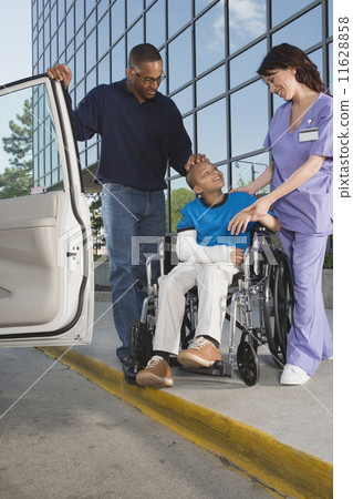 African boy in wheelchair leaving hospital with father African boy in wheelchair leaving hospital with father 11628858