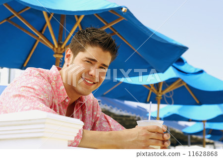 Young man holding drink outdoors 11628868