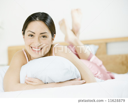 Hispanic woman laying on bed 11628879
