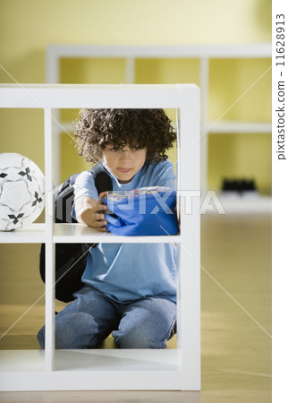 Hispanic boy putting away lunch box Hispanic boy putting away lunch box 11628913