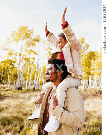 African father holding daughter on shoulders 11628934