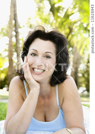 Hispanic woman laying in grass 11628943