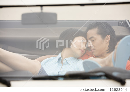 Asian couple hugging in convertible 11628944