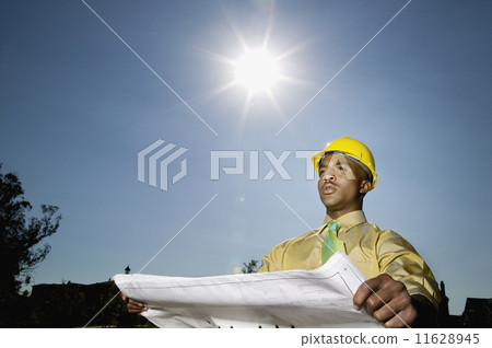 African American businessman holding blueprints 11628945