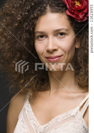 Close up of Hispanic woman smiling with flower in hair Close up of Hispanic woman smiling with flower in hair 11628955