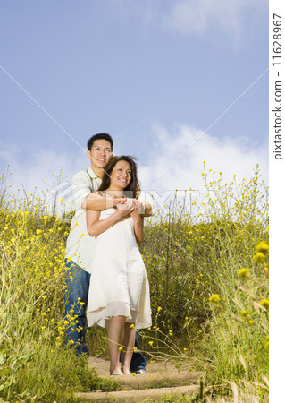 Asian couple hugging in field Asian couple hugging in field 11628967